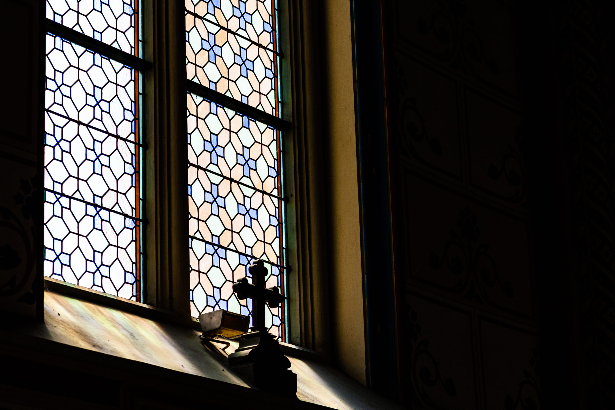 Kreuz vor einem Kirchenfenster