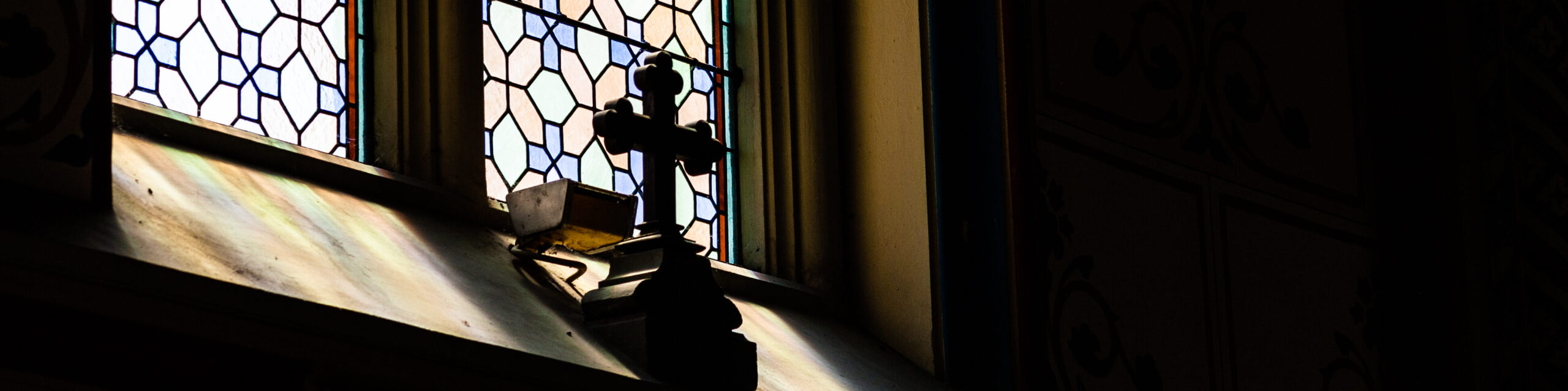 Kreuz vor einem Kirchenfenster