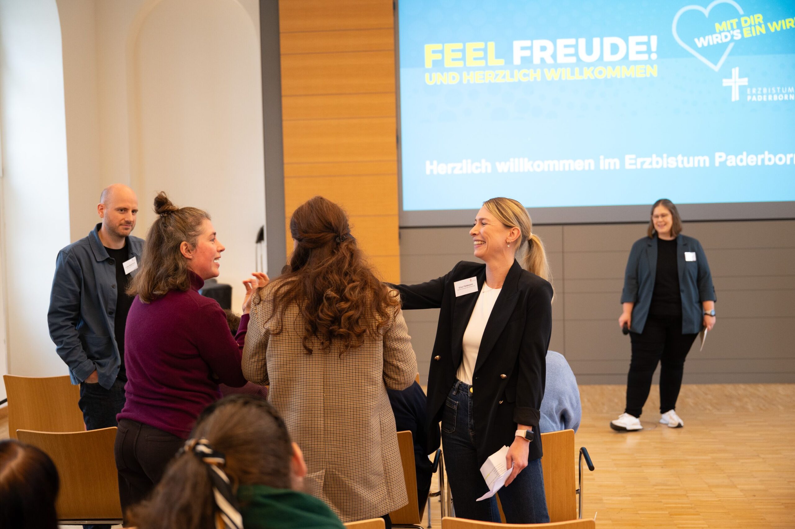 Eine Frau reicht anderen das Mikrofon.